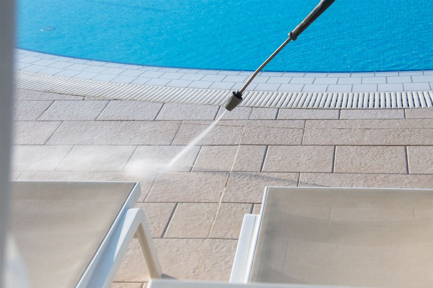 Pool deck pavers being pressure washed